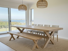 Load image into Gallery viewer, Dining area with wooden table and bench in a bright room with large windows.
