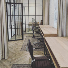 Load image into Gallery viewer, A modern study desk with black tubular metal legs and a wooden tabletop, featuring cable management holes on the top and shelf under the desk.