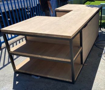 Custom made kitchen island with black metal legs and side storage.
