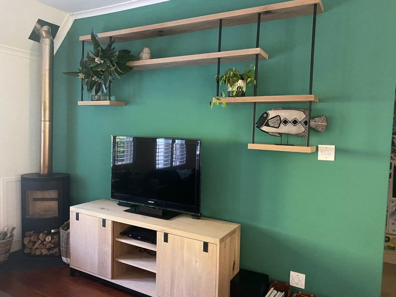 Custom made floating wooden shelves with black metal rods and wooden tv unit. 