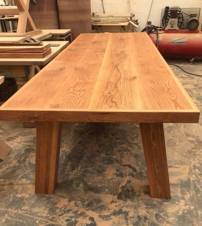 Custom made wooden dining room table with straight legs.