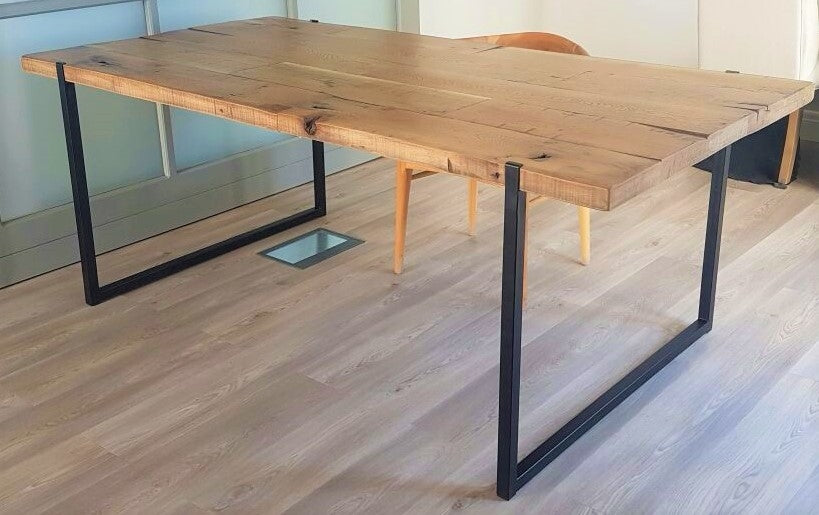 Custom made wooden dining room table with black metal legs.
