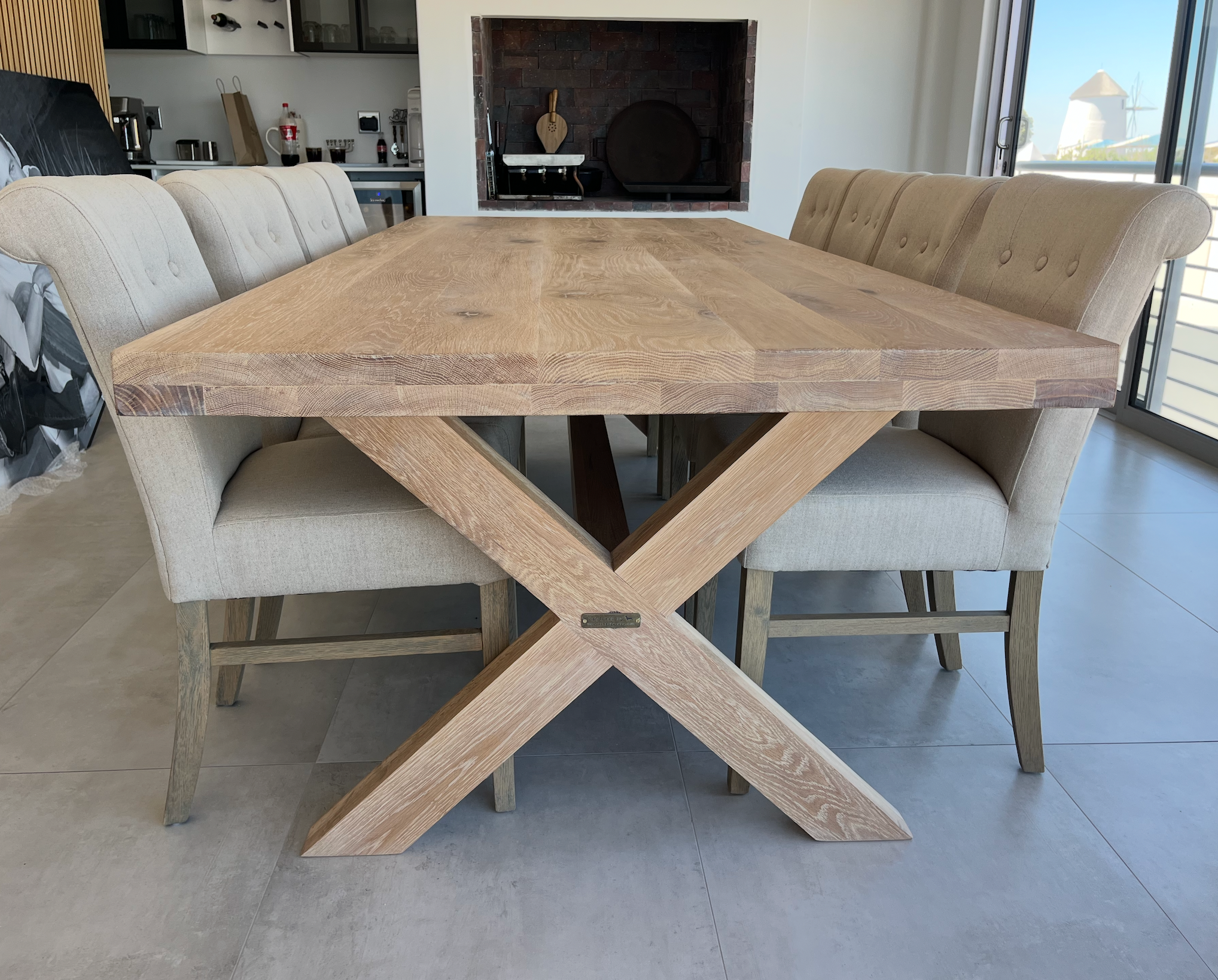 Wooden dining table with X-shaped legs in a modern kitchen setting