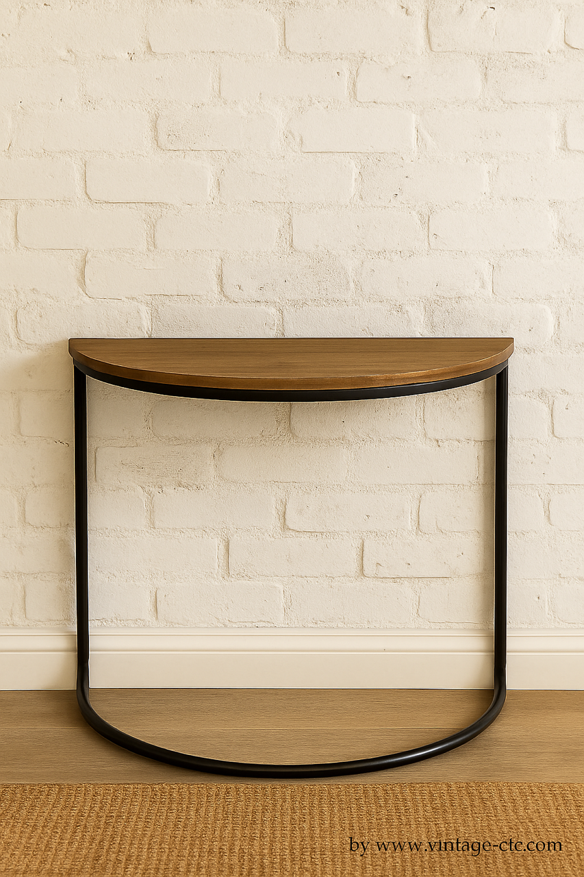 Wooden half-moon table with black metal frame against a white brick wall.