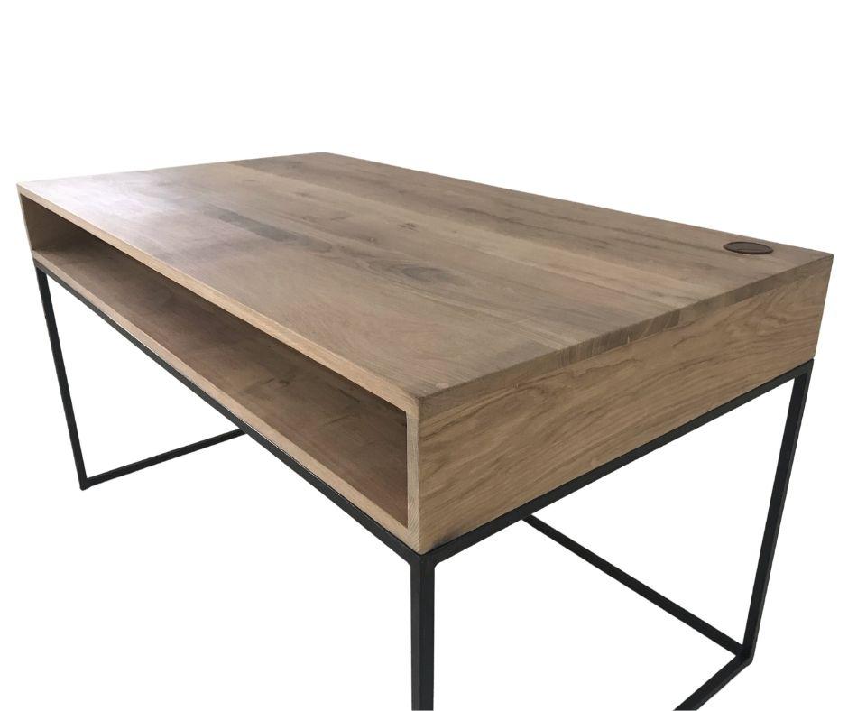 A modern study desk with black tubular metal legs and a wooden tabletop, featuring cable management holes on the top and shelf under the desk.