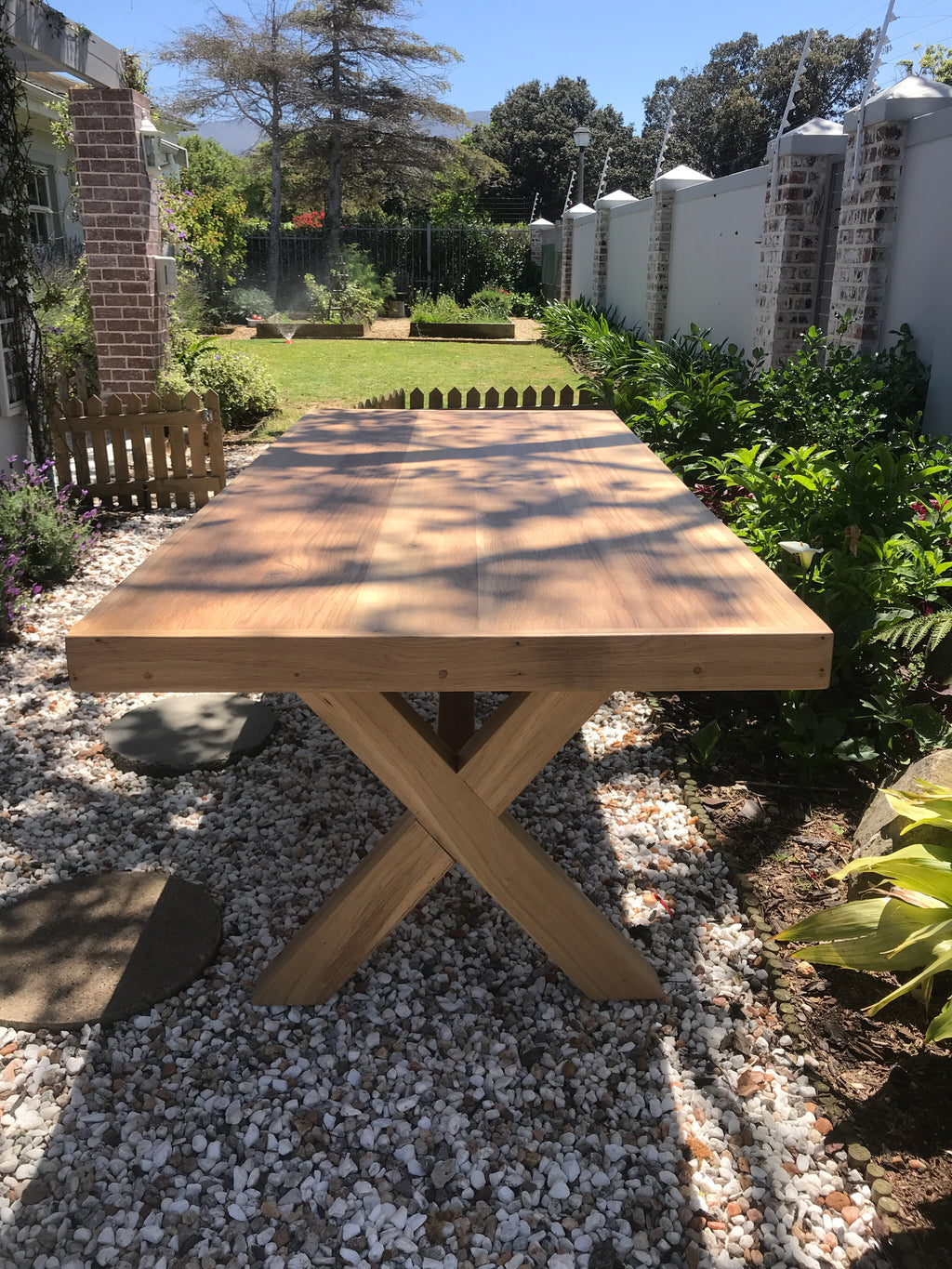 The Framed Border Cross Leg Table has a solid timber top with a framed perimeter border and a sturdy cross-leg base. Custom made to order in SA.