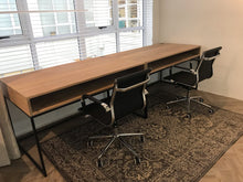Load image into Gallery viewer, A modern study desk with black tubular metal legs and a wooden tabletop, featuring cable management holes on the top and shelf under the desk.
